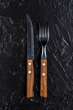 Siyah arka planda ahşap çatal bıçak..
