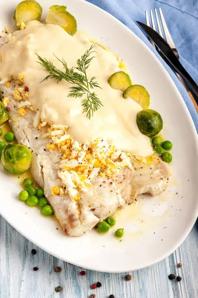 Филе белой рыбы в густом соусе с овощным гарниром — стоковое фото