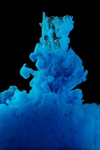 Color cloud of paint. Acrylic ink spreads in water. Colored blue abstraction is isolated on a black background. Close up.