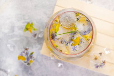 Açık gri arka planda buzlu ve çiçekli şampanya kokteyli. Hafif yaz içkisi. Yakın plan. Üst görünüm. 