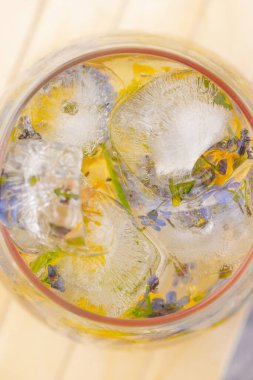 Açık gri arka planda buzlu ve çiçekli şampanya kokteyli. Hafif yaz içkisi. Yakın plan. Üst görünüm. 