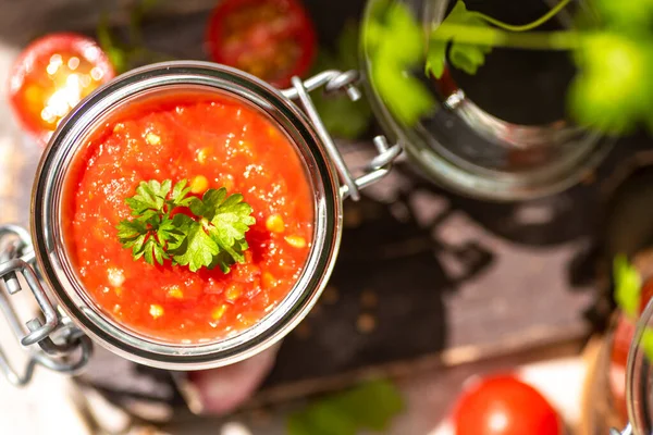 Tomato salsa in a glass jar. Homemade spicy tomato sauce with chilli, garlic and lime. Preparation of food for the winter. Ecological healthy food.
