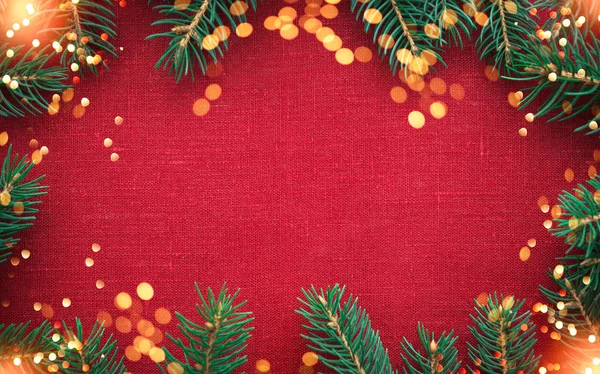 Christmas frame with Christmas tree and ornaments on red canvas background