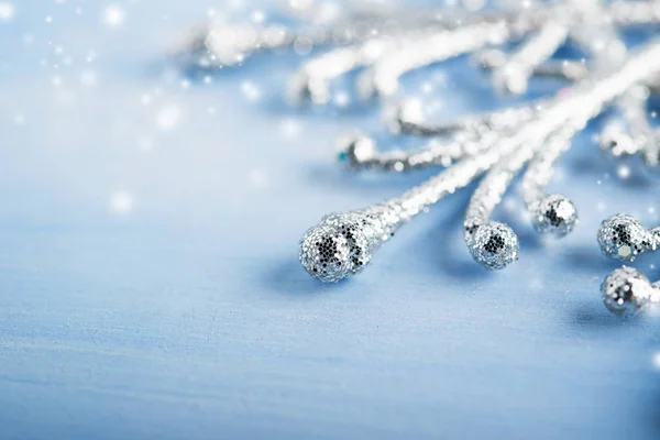 光の青い木製の背景に銀のクリスマス雪の結晶 — ストック写真