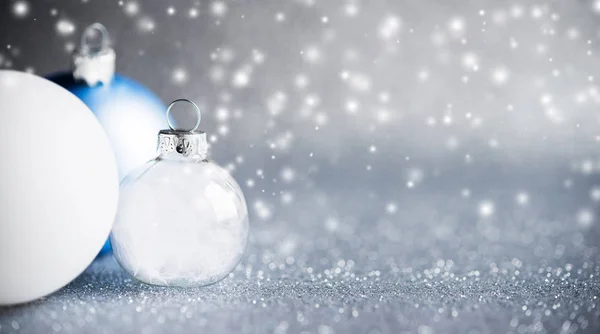 银色和白色圣诞装饰品在闪闪发光的假日背景 — 图库照片