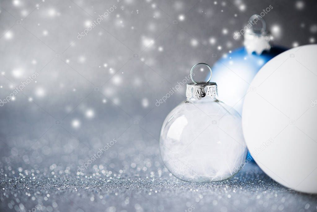 Blue, silver and white xmas ornaments on glitter holiday background