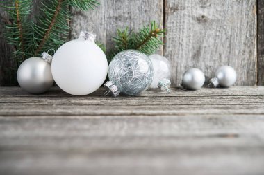  Eski gri ahşap arka plan üzerinde beyaz ve gümüş Noel süsleri