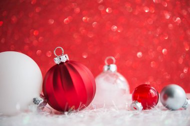 Kırmızı parlak zemin üzerine beyaz, kırmızı ve gümüş Noel süsleri