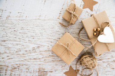 Neşeli Noel ve mutlu tatil tebrik kartı, çerçeve, banner. Yeni yıl. El yapımı hediyeler Noel armağan üstünde eski beyaz tahta arka plan görünüm üst. Kış tatil tema. Düz yatıyordu.