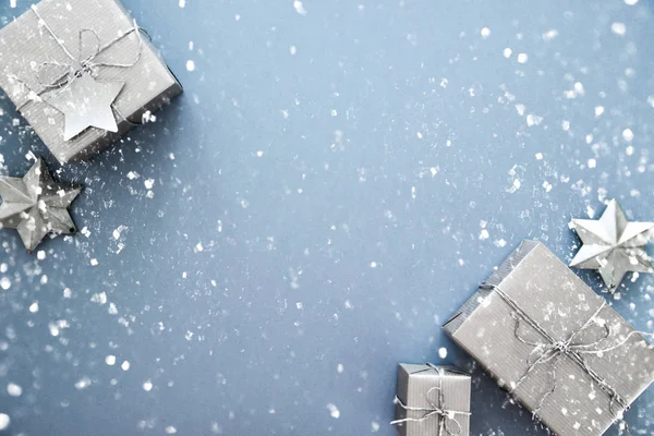 Christmas silver handmade gift boxes on blue background top view. Merry Christmas greeting card, frame. Winter xmas holiday theme. Happy New Year. Flat lay