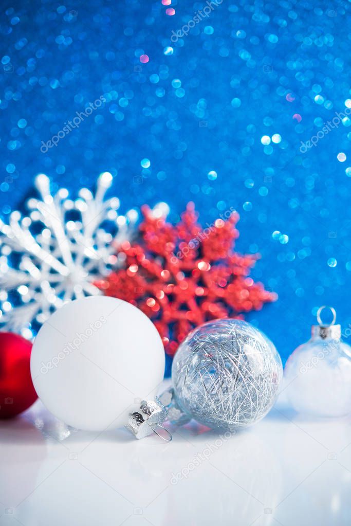 White, red and silver Christmas decorations on blue background