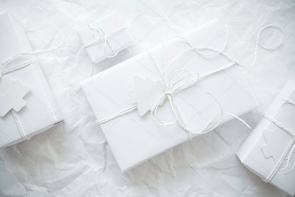 Christmas white handmade gift boxes on white crumpled background top view. Merry Christmas greeting card, frame. Winter xmas holiday theme. Happy New Year. Flat lay