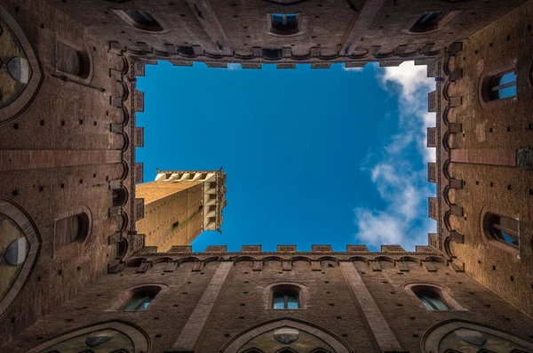 View from the courtyard of medieval Siena town hall, Palazzo Pubblico, to Mangia Tower, Torre del Mangia, and blue sky, Tuscany, Italy — Stock Photo, Image