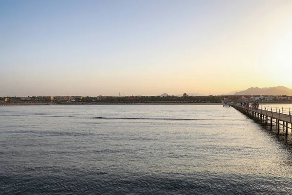 Pastel gün batımında sakin deniz suyunun panoramik manzarası