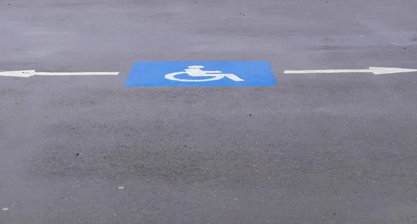 traffic blue sign drawn on asphalt, indicates directions for disabled