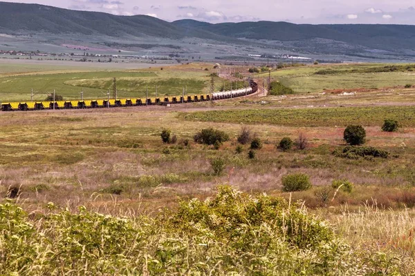 Beautiful landscape, railway train through the green field, high mountains, Bulgaria