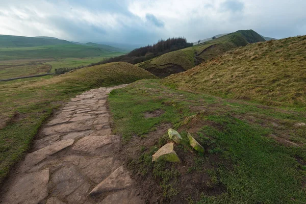 Un petit sentier rocheux traverse les collines du Peak District lors d'une journée d'hivers brumeux — Photo