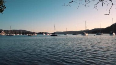 Yelken tekneleri Cumbria, Ingiltere 'de gün batımı sırasında sakin bir Windermere Gölü üzerinde oturmak