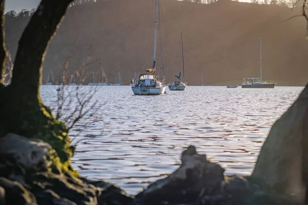 Sailing boats sit stationary on Lake Windermere - Lake District, Cumbria - during an early spring Sunset from Bowness on Windermere - March 2019 — Stock Photo, Image