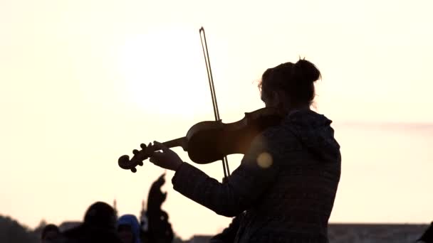 En kvinnlig violinist spelar musik på en publik med sitt band under solnedgången i Prag-april 2019 — Stockvideo