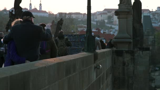 Prague, Tchéquie - 12 avril 2019: Touristes sur le célèbre pont Charles pendant le coucher du soleil pendant les vacances de Pâques — Video