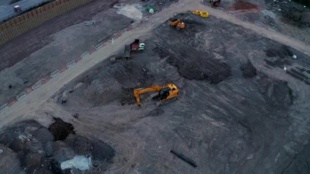 Imágenes aéreas 4K de una excavadora JCB grande en una obra de construcción — Vídeos de Stock
