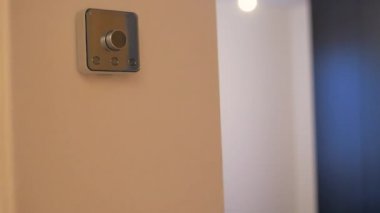 Sheffield, İngiltere - 29 Mayıs 2019: Mavi üstteki beyaz beyaz beyaz bir erkek hive termostatı ile etkileşime giriyor ve evin sıcaklığını değiştiriyor.
