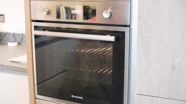 SHEFFIELD, UK - 29TH MAY 2019: A white caucasian male puts a meal for one into a hoover fan oven - 4K footage — Stock Video