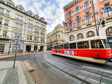Prag'daki parlak kırmızı tramvay, Nisan ayında güneşli ve parlak bir günde müşterileri şehrin dört bir yanında taşır.