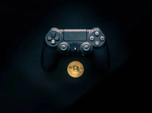 Bitcoin sitzt unter einem Playstation-4-Controller — Stockfoto