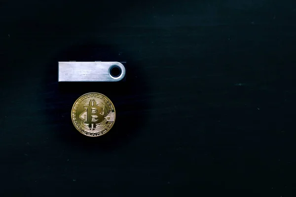 Bitcoin físico sentado debajo de un libro mayor Nano S cartera fría segura — Foto de Stock