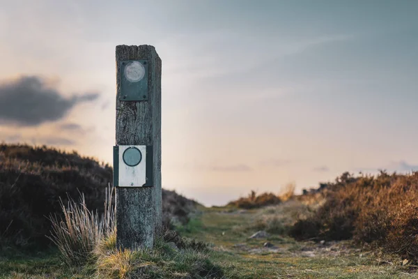 Um sinal em branco num parque nacional no Reino Unido com um pôr-do-sol calmo atrás dele — Fotografia de Stock