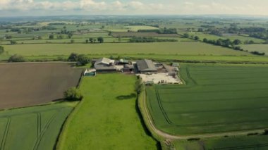 North Yorkshire, İngiltere'de tarlalar arasında bir çiftliğin havadan 4k görüntüleri