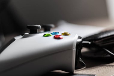 Düğmelere odaklanan parlak ışıklı bir odada beyaz xbox one kumandasının yakın çekim