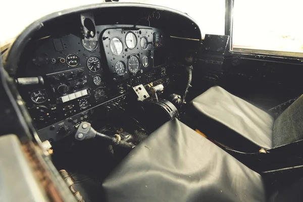 Nahaufnahme eines Flugzeugcockpits mit Instrumenten und Schalttafeln aus einem alten, verlassenen zweisitzigen Flugzeug — Stockfoto
