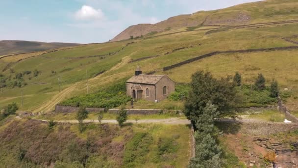 4k luchtbeelden pannen rond een kerk die het prachtige Peak District onthult — Stockvideo