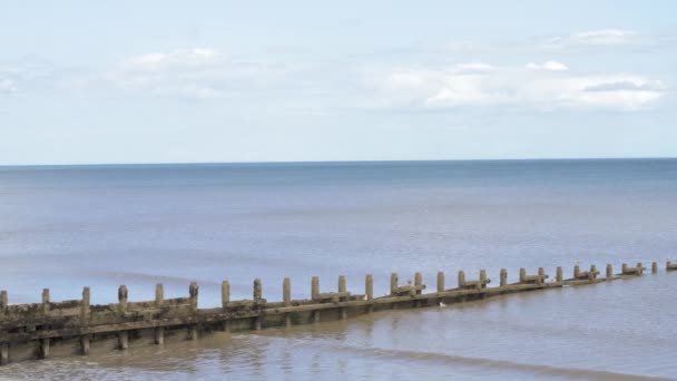 Uma maré baixa calma em uma praia de areia na Inglaterra durante um verão quente — Vídeo de Stock