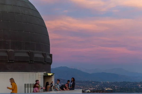 ラ、アメリカ - 2018年11月3日:有名なグリフィス天文台の上の観光客は、黄金の夕日の写真を撮ります — ストック写真