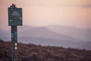 Derbyshire, İngiltere - 26 Ağustos 2019: Peak District Milli Parkı'nda güzel pembe gün batımı sırasında çekilen halka açık bir Patika tabelası