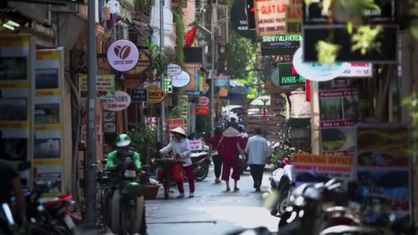 Hanoi, Vietnam - 10 Ekim 2019: İnsanlar scooterların ve motosikletlerin yanında dar sokaklarda yürüyor — Stok video