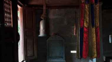 Vietnam 'da Bich Dong Pagoda' da karanlık bir oda. Dini eşyalar ve odada metal bir zil var.