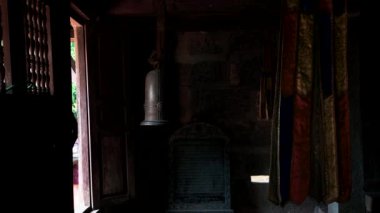 Vietnam 'da Bich Dong Pagoda' da karanlık bir oda. Dini eşyalar ve odada metal bir zil var.