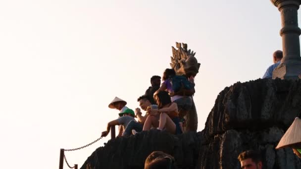 Hang Mua, Vietnam - 18 oktober 2019: Toeristen zitten naast het beroemde Drakenbeeld op de top van Hang Mua grotten — Stockvideo