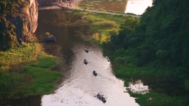 Touristes sur une excursion en bateau autour de Hang Mua sur les rivières de Tam Coc au coucher du soleil — Video