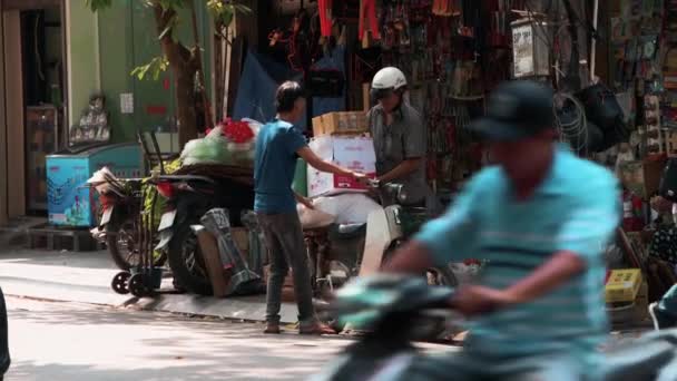 Hanoi, Vietnam - 21 de octubre de 2019: Los vietnamitas locales cargan grandes mercancías pesadas en un ciclomotor — Vídeos de Stock