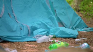 Bira ve plastik şişeler terk edilmiş bir çadırın yanına bırakılmış.