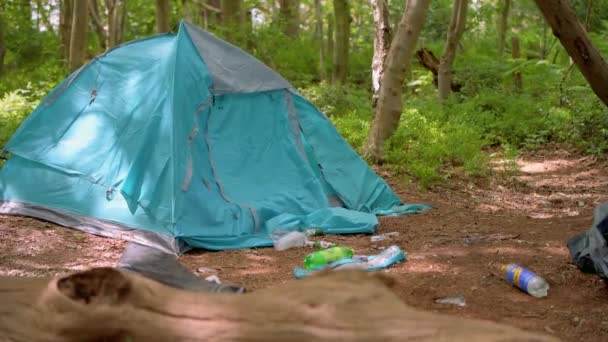 Surrey, Reino Unido - 14 de junio de 2020: Basura y basura abandonada junto a una tienda abandonada en un camping en un bosque — Vídeo de stock