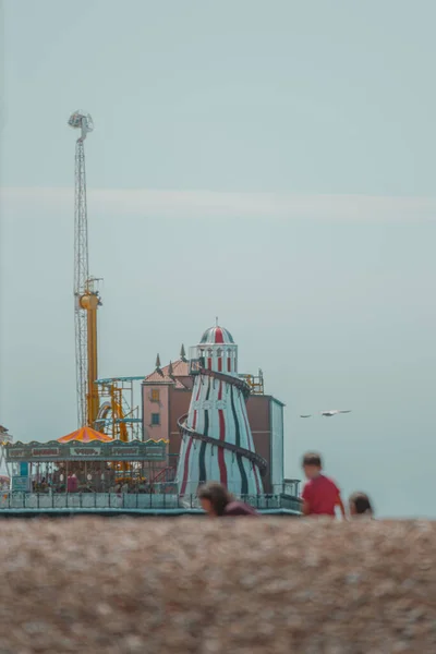 Brighton pier rides in the background behind a family playing on the beach 2020 — Stock Photo, Image