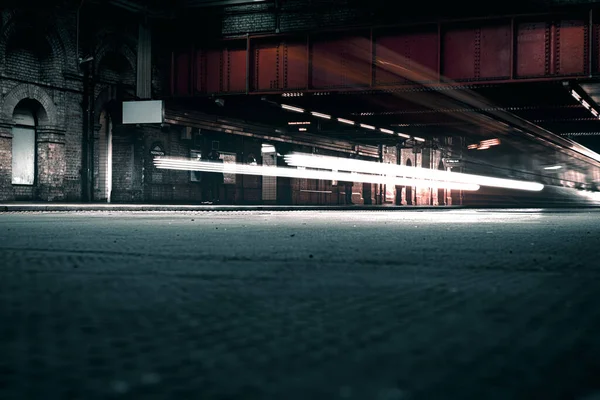 Londra 'daki yeraltı tren ağının açık hava istasyonundaki parlak ışıklarla uzun metrajlı görüntüleri. Stok Fotoğraf