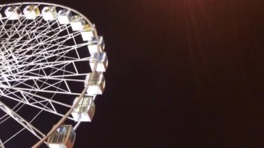 Dönme dolap. Karanlık bir arka plan üzerinde yüksek aydınlık atlıkarınca. Akşam video. Siyah arka plan